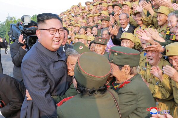 Северокорейский лидер Ким Чен Ын вместе с участниками 5-й Национальной конференции ветеранов Корейской войны