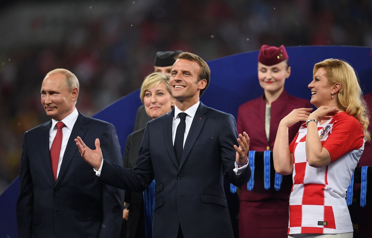 Президент РФ Владимир Путин, президент Франции Эммануэль Макрон и президент Хорватии Колинда Грабар-Китарович (слева направо) на церемонии награждения победителей чемпионата мира по футболу FIFA 2018 года на стадионе Лужники