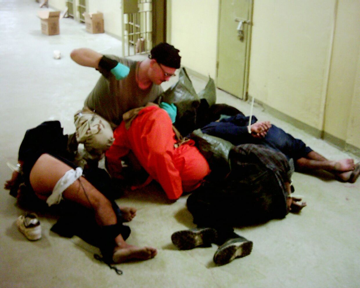 Американский военный избивает заключенных в тюрьме Абу-Грейб в Багдаде, Ирак. 2003