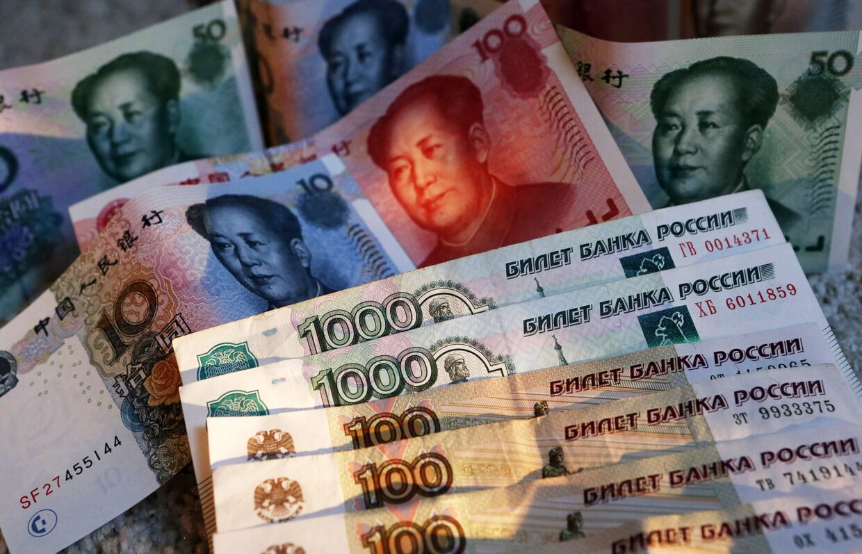 Китайские банкноты номиналом в 100, 50, 20, 10 и 5 юаней и российские 1000 и 100 рублевые купюры.