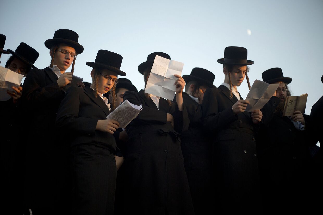 Ультраортодоксальные евреи молятся на берегу реки Хаяркон