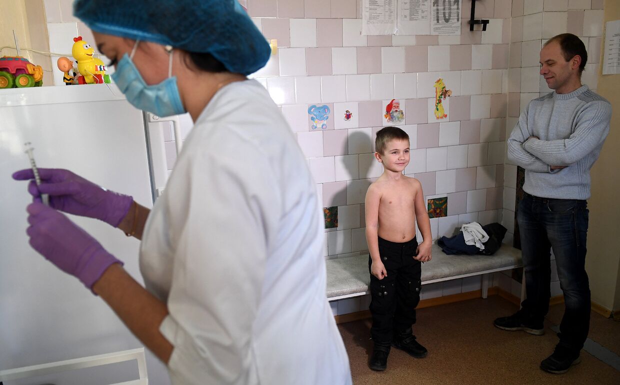 Медсестра готовит шприц для вакцинации против кори в детской поликлинике в Киеве