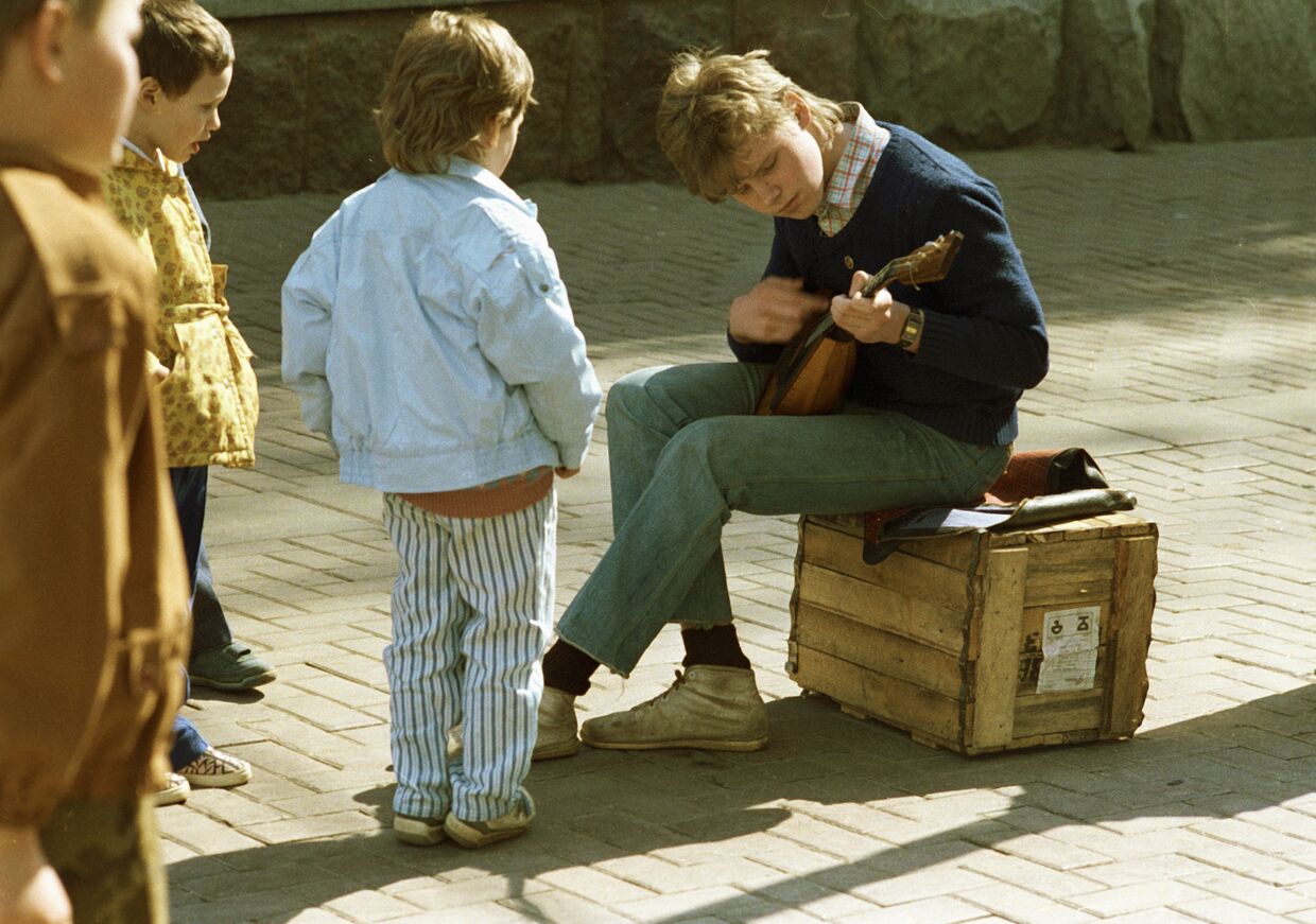 Дети наблюдают за игрой уличного музыканта на Старом Арбате
