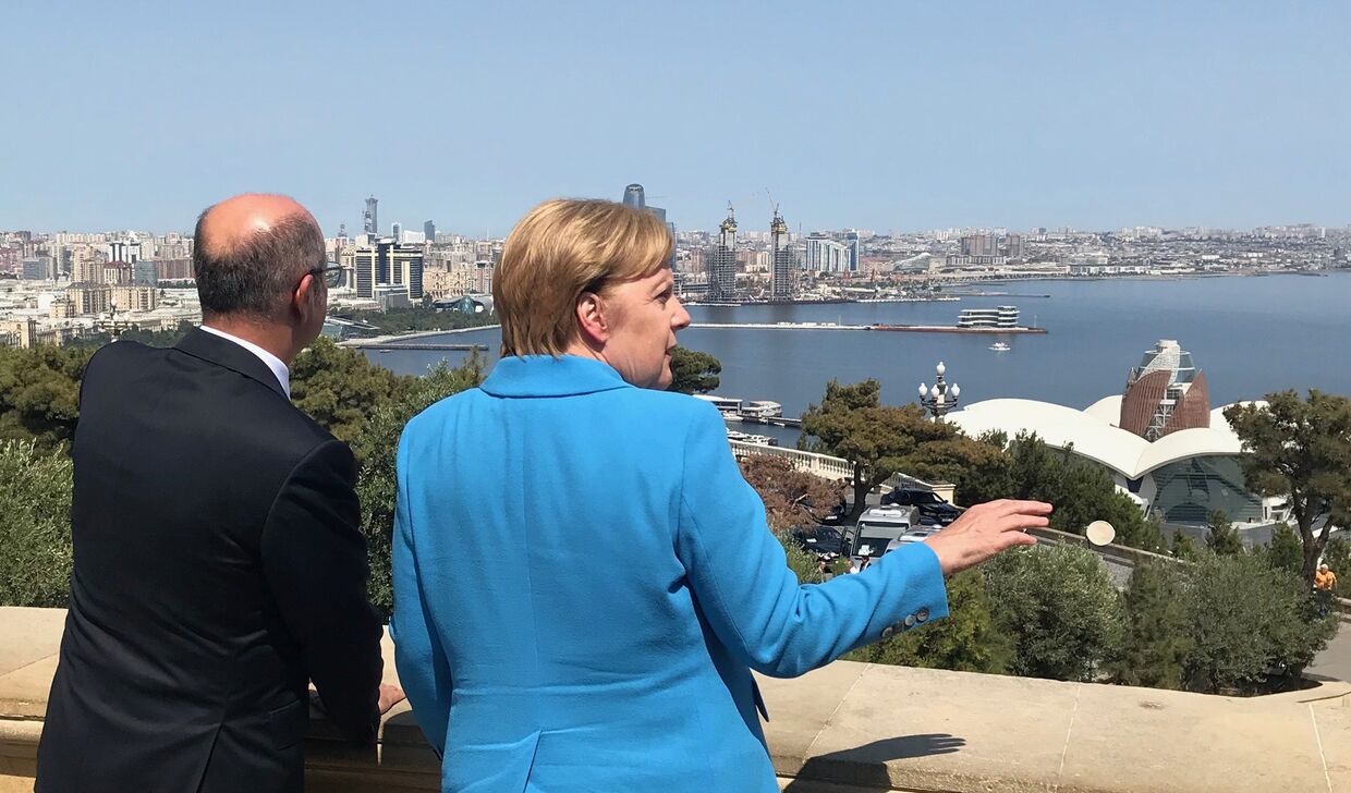 Канцлер Германии Ангела Меркель и министр энергетики Азербайджана Парвиз Шахбазов на фоне панорамы города Баку, Азербайджан. 25 августа 2018