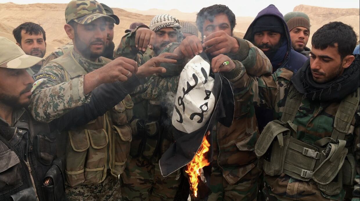 Сирийские солдаты сжигают флаг террористической группировки Исламское государство (запрещенная в РФ), снятый с крепости Пальмиры