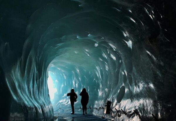 Посетители искусственной ледяной пещеры внутри ледника Мер-де-Глас во французских Альпах