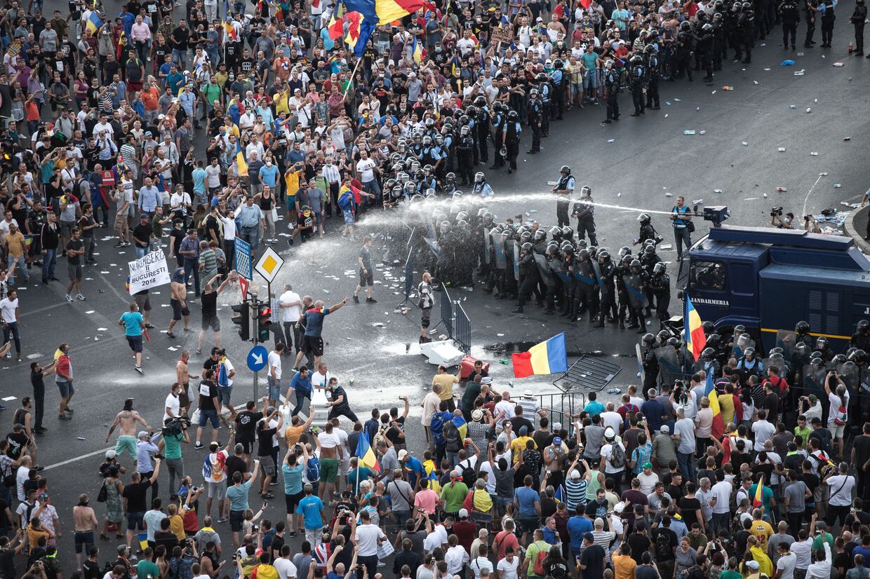 Разгон демонстрантов водометом перед зданием правительства в Бухаресте