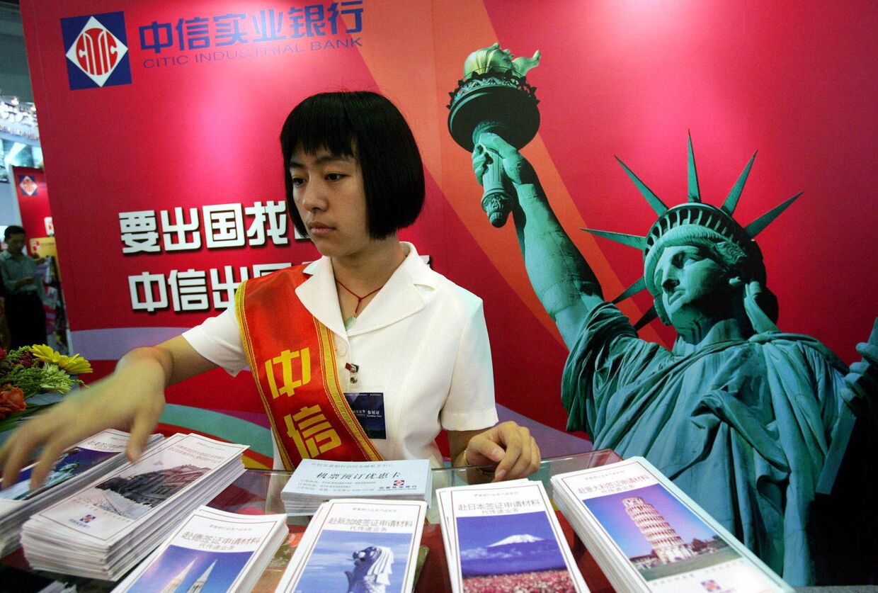 Девушка у стенда китайской компании CITIC на Международной выставке финансовой культуры в Пекине, КНР