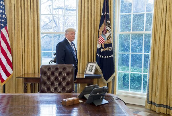 Президент США Дональд Трамп у фотографии своего отца Фреда Трампа в Овальном кабинете в Белого дома в Вашингтоне Президент США Дональд Трамп у фотографии своего отца Фреда Трампа в Овальном кабинете в Белого дома в Вашингтоне