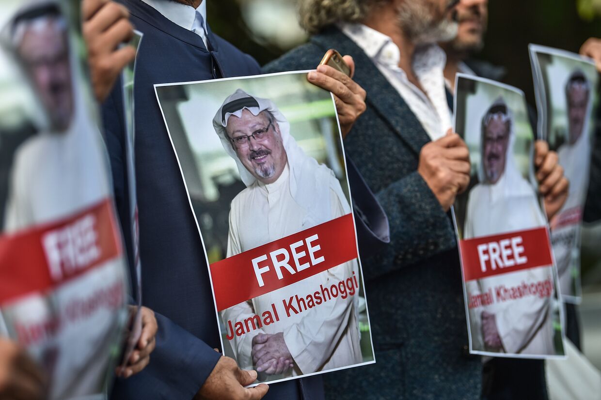 Демонстранты держат фотографии пропавшего журналиста Джамала Хашоги перед консульством Саудовской Аравии в Стамбуле