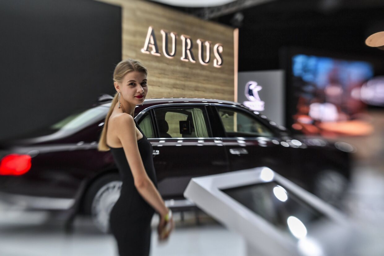 Девушка у автомобиля Aurus Senat на Московском международном автомобильном салоне 2018