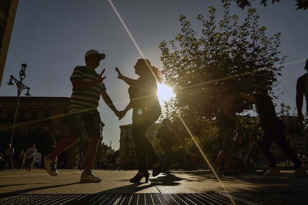 Люди танцуют осенним вечером в Памплоне на севере Испании