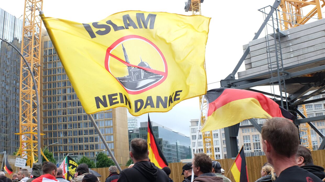 Участники акции против про-иммигрантской политики канцлера Германии Ангелы Меркель в Берлине