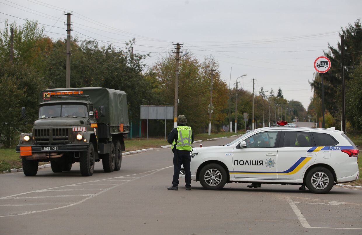 Сотрудники полиции Украины останавливают автомобили на дороге в Черниговской области после взрыва на военном складе. 9 октября 2018