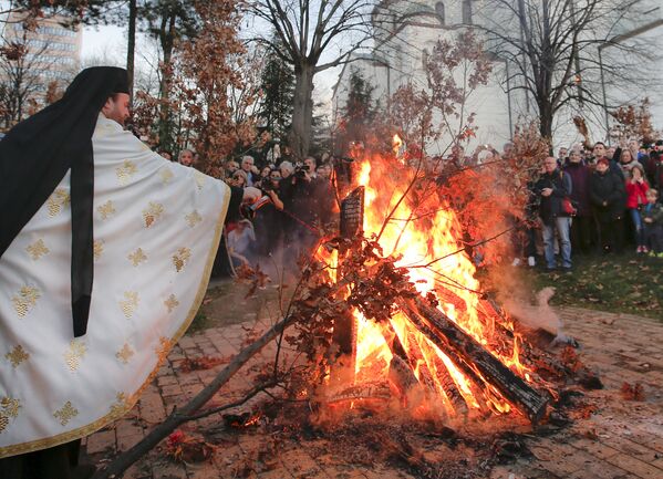 Священник сжигает ветви дуба у храма Святого Саввы в Белграде