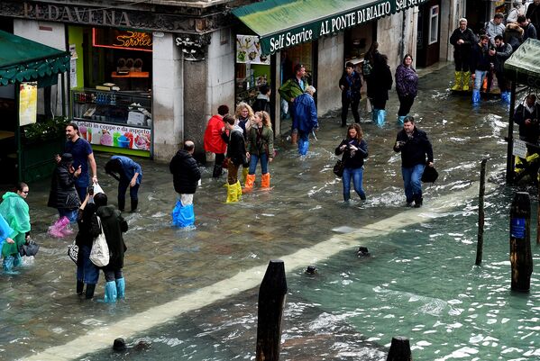 Туристы на затопленной улице возле моста Риальто