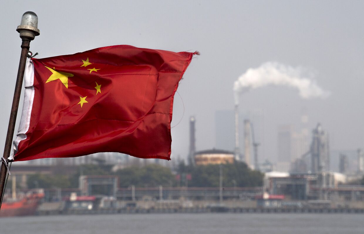 Китайский флаг перед шанхайским нефтеперерабатывающим заводом компании Gaoqiao