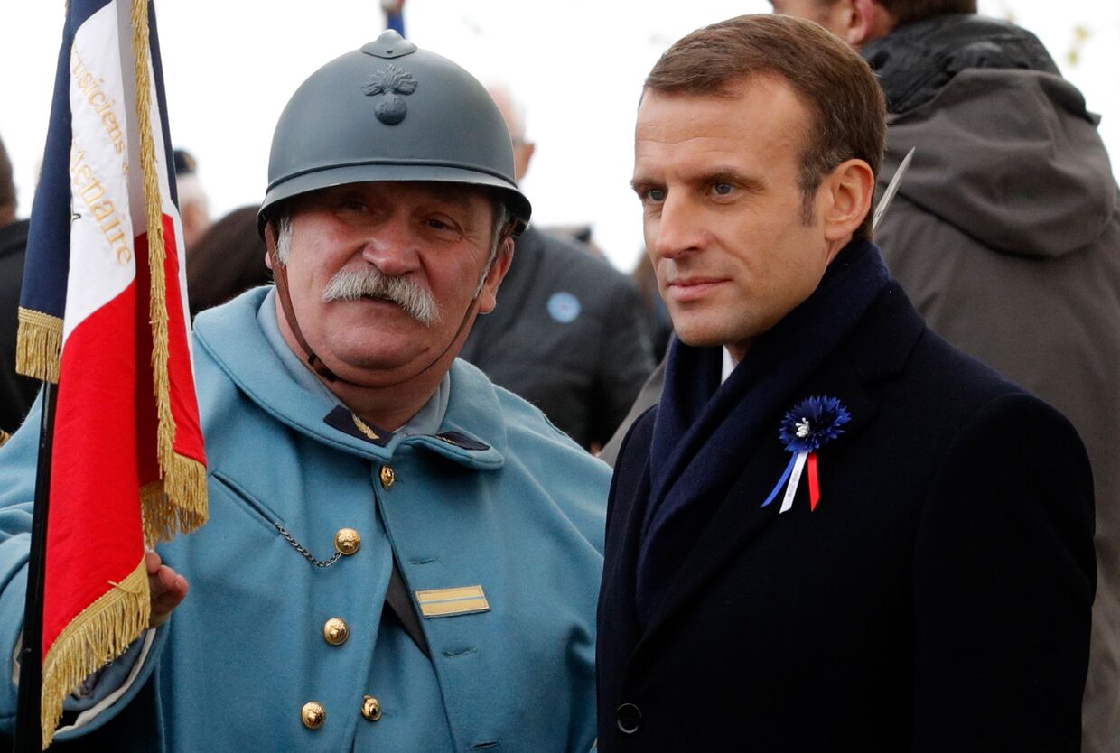 Президент Франции Эммануэль Макрон и реконструктор, одетый как солдат французской армии времен Первой мировой войны, во время памятной церемонии в коммуне Моранж. 6 ноября 2018