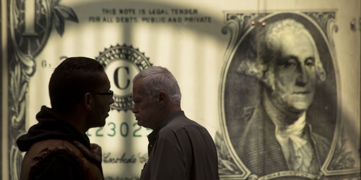 Мужчины возле баннера с изображением американского доллара возле обменного пункта