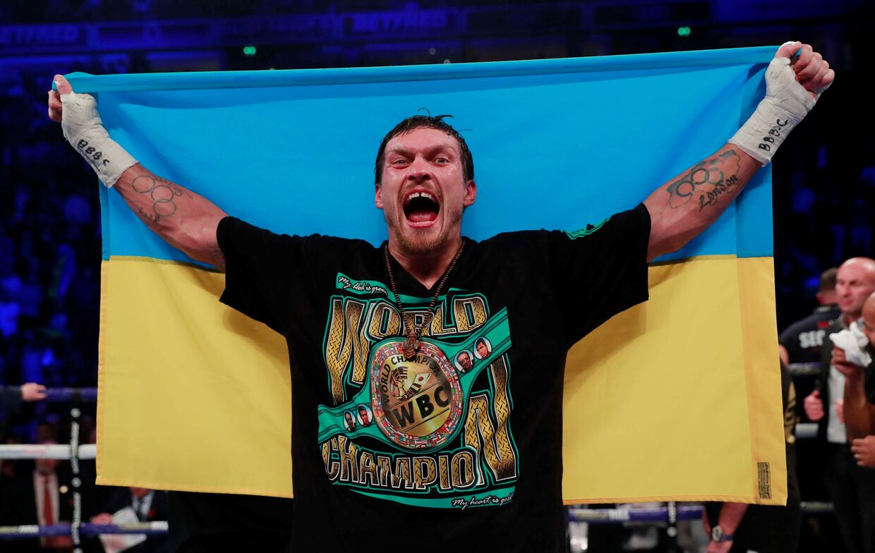 Украинский боксер Александр Усик празднует победу в бою с британцем Тони Беллью