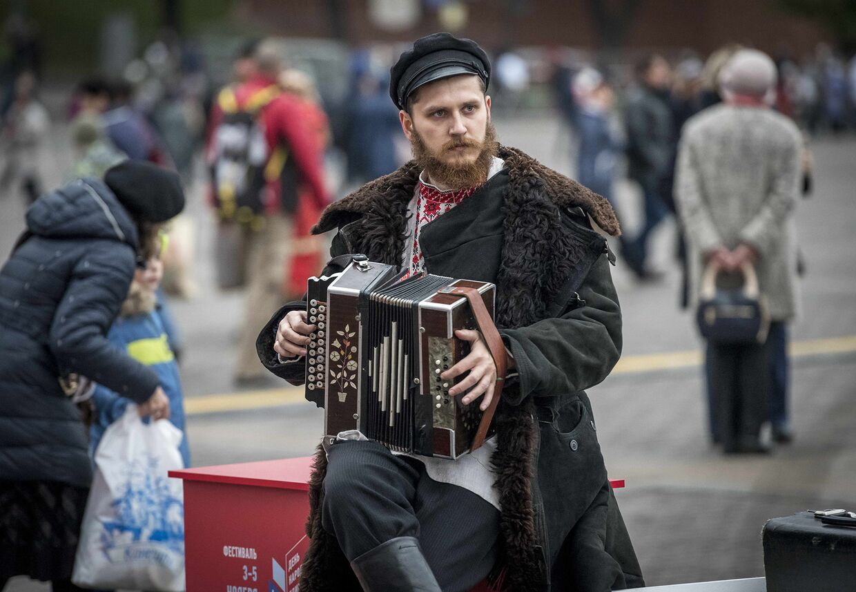 Музыкант играет на аккордеоне на Манежной площади в центре Москвы