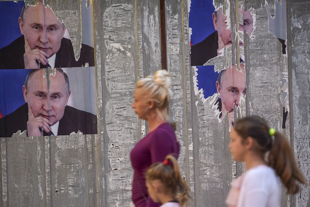 Плакаты с изображением Владимира Путина на улице города Митровицы во время празднования Дня Европы