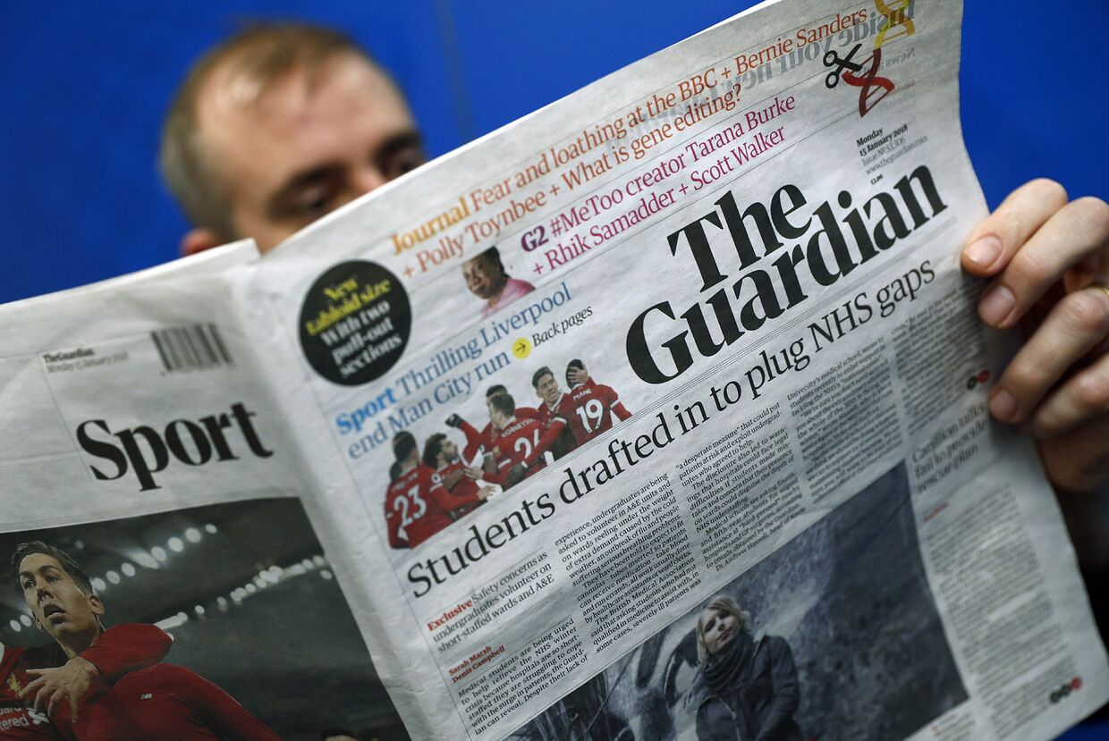 Мужчина читает газету The Guardian в Лондоне