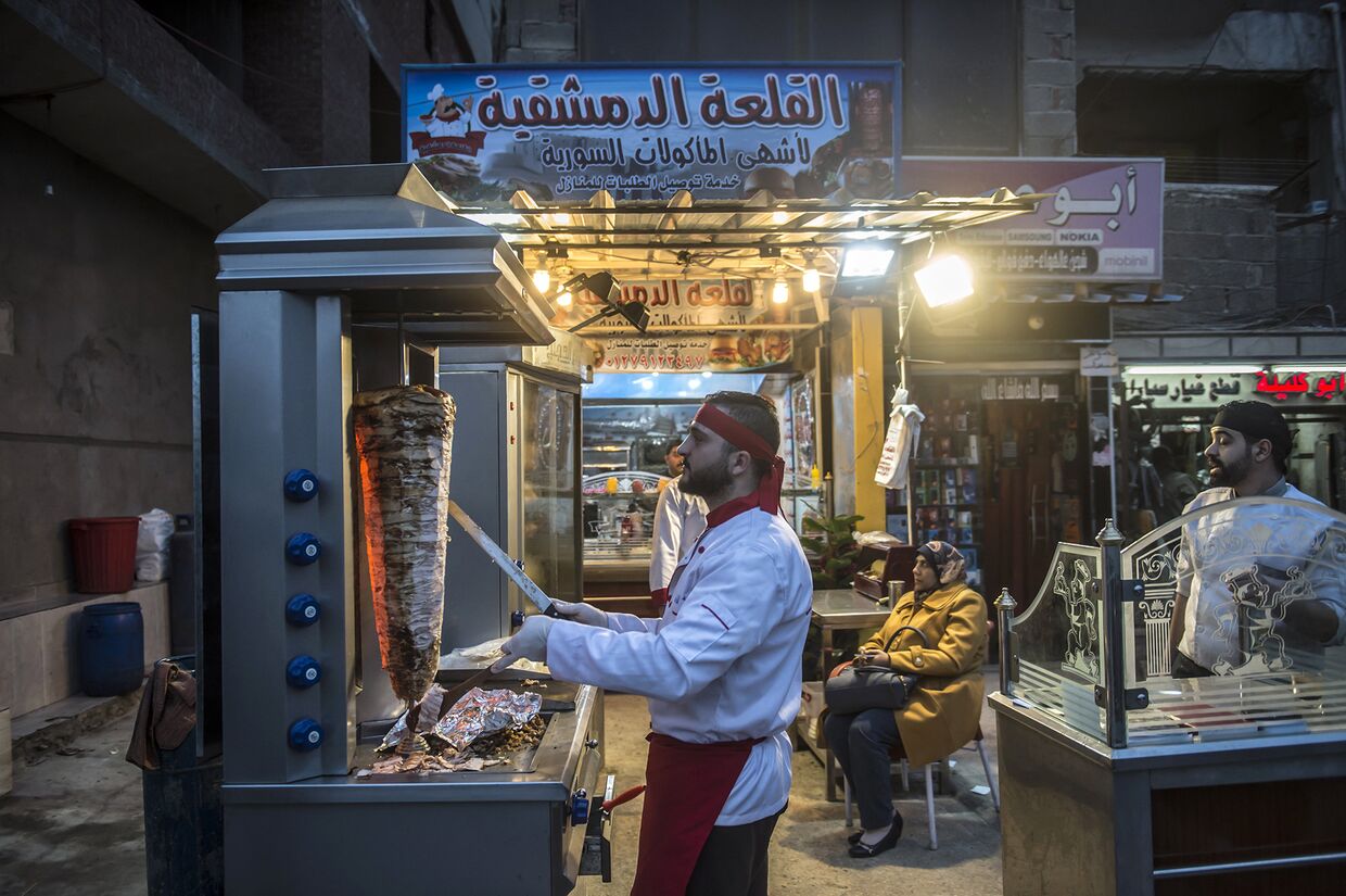 Сирийский беженец работает в ресторане в Александрии, Египет