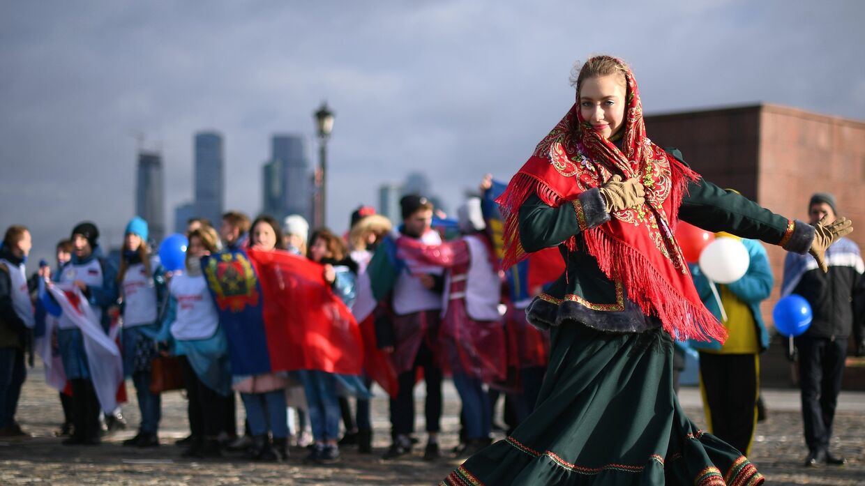 Волонтеры во время флешмоба, где будут развернуты флаги всех 85 регионов России в честь Дня народного единства на Поклонной горе в Москве