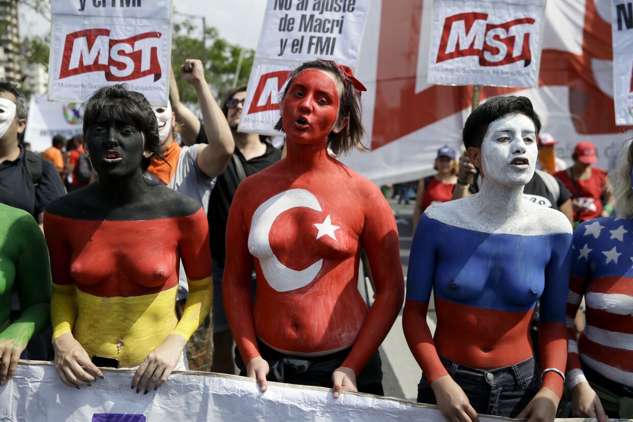 Протестующие в Буэнос-Айресе, раскрашенные в цвета флагов Германии, Турции и России