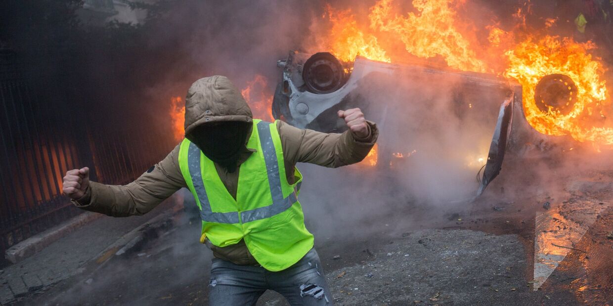 Автомобиль, горящий во время протестной акции движения автомобилистов желтые жилеты Автомобиль, горящий во время протестной акции движения автомобилистов желтые жилеты