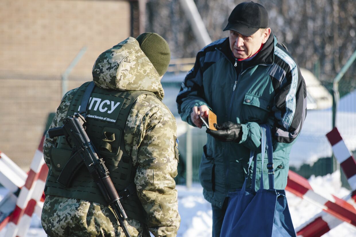 Украинский пограничник проверяет документы на границе с РФ в Гоптовке