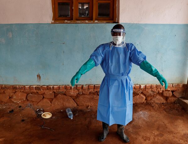 Медицинский работник в защитном костюме в больнице для больных Эболой в Бвана-Сури