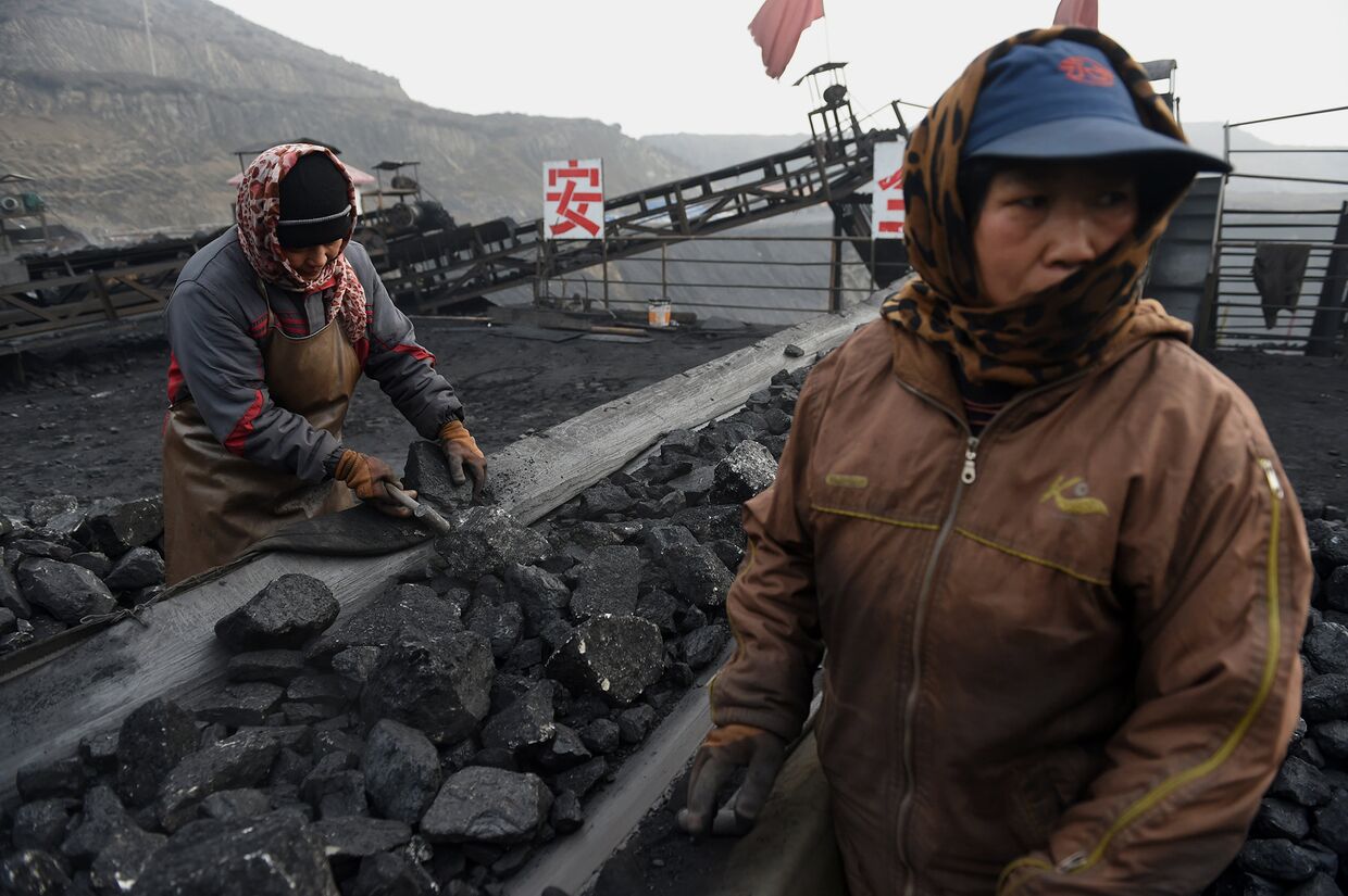 Рабочие сортируют уголь возле угольной шахты в Датуне, Китай
