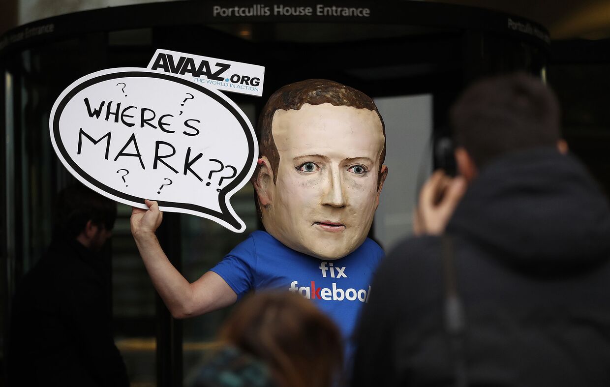 Активист, одетый в маску генерального директора Facebook Марка Цукерберга