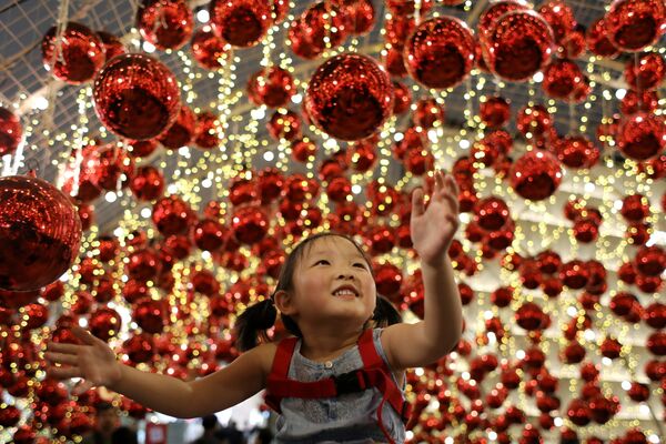 Девочка смотрит на рождественские украшения в торговом центре «Эмпориум»