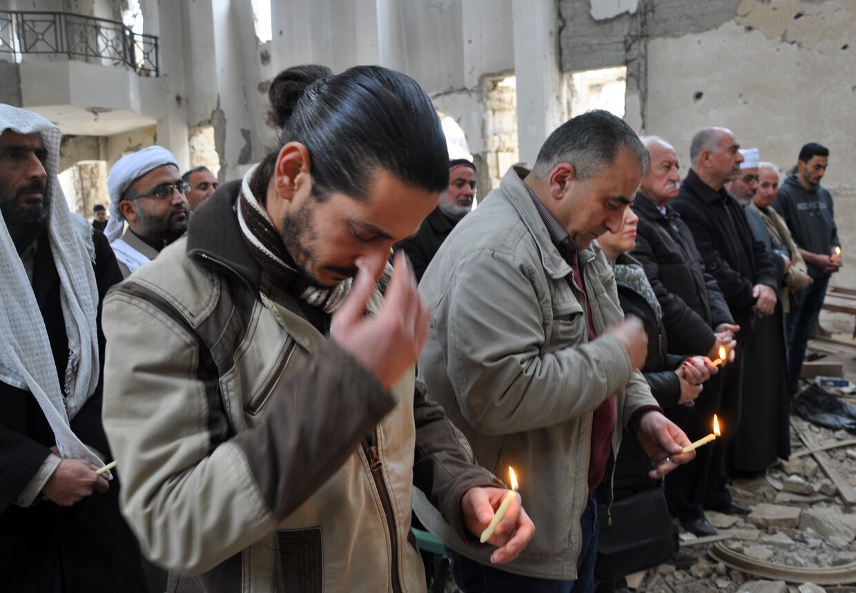 Христиане во время молитвы в церкве в городе Дейр-эз-Зор, Сирия