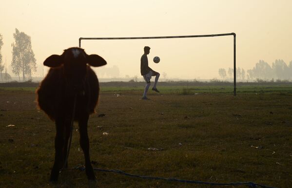 Индийский мальчик играет в футбол на окраине Джаландхара