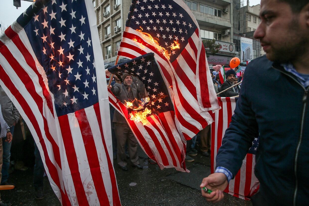 Иранцы сжигают флаги США во время церемонии по случаю 40-й годовщины Исламской революции в Тегеране