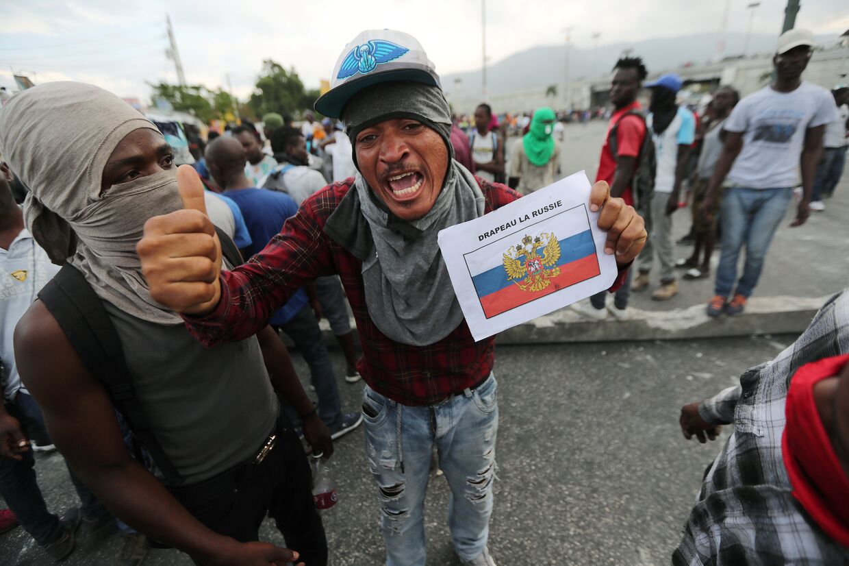 Демонстранты во время антиправительственных протестов в Порт-о-Пренсе