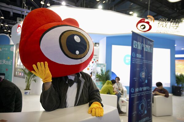 Сотрудник на стенде китайского сайта микроблогов Sina Weibo Сотрудник на стенде китайского сайта микроблогов Sina Weibo