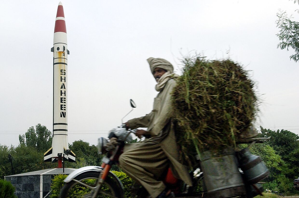 Местный житель проезжает мимо пакистанской баллистической ракеты «Шахин» в Исламабаде