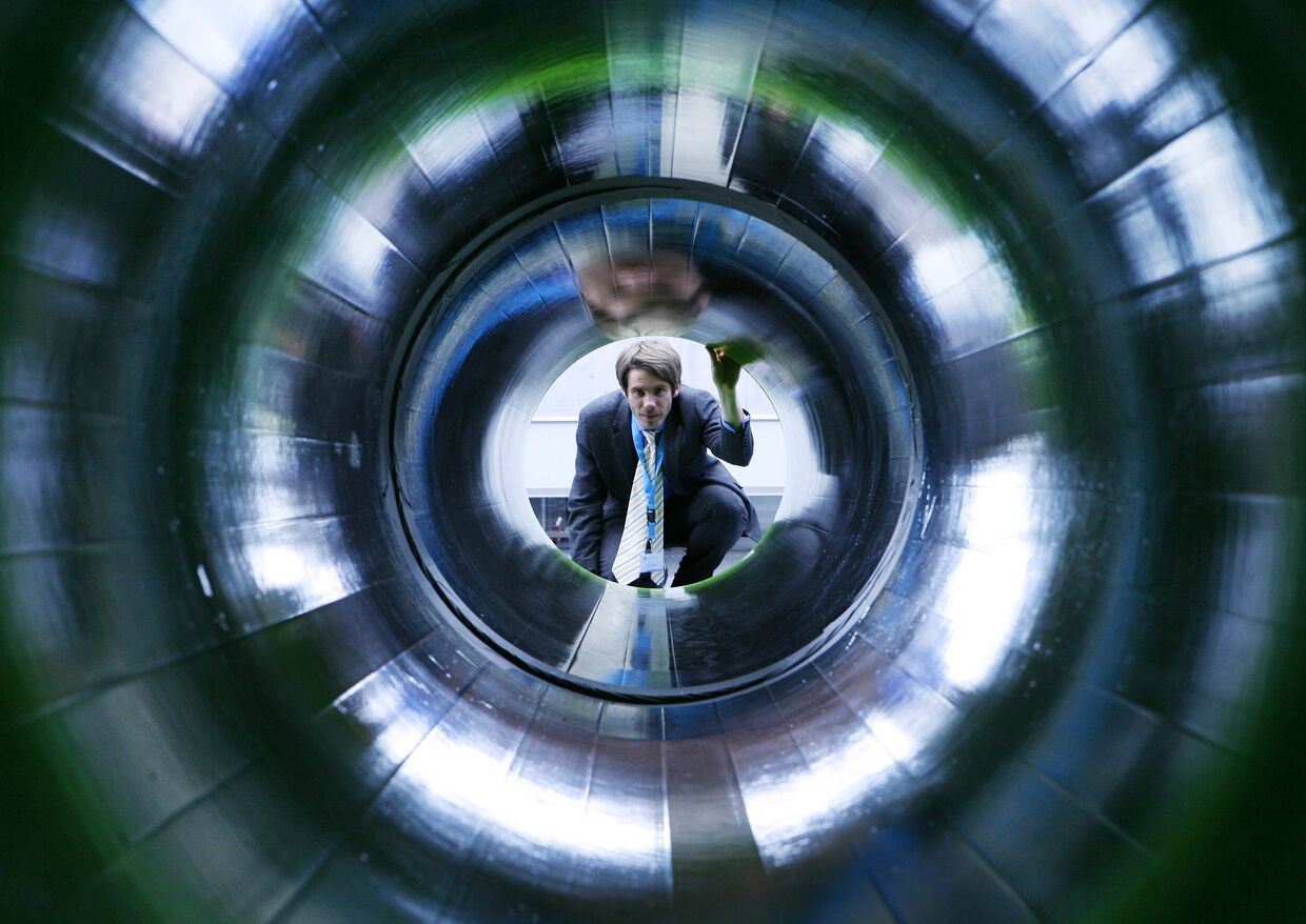 Мужчина заглядывает в трубу, представляющую газопровод «Северный поток», на промышленной выставке в Ганновере
