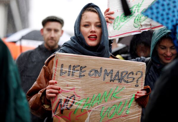 Участники акции протеста, требующие принятия срочных мер по борьбе с изменением климата, в центре Амстердама, Нидерланды.