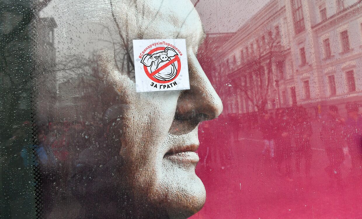 Наклейка с изображением свиньи на предвыборном плакате президента Украины Петра Порошенко в Киеве