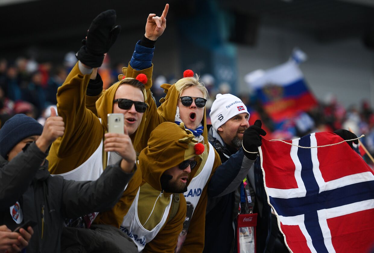 Норвежские и российские болельщики на трибуне во время эстафеты 4x10 км среди мужчин в соревнованиях по лыжным гонкам на XXIII зимних Олимпийских играх