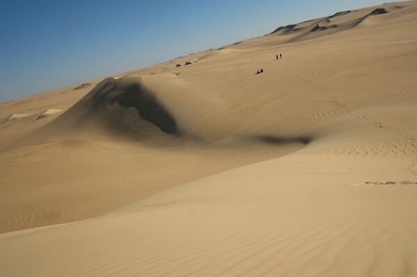 Люди у песчаной дюны в пустыне Египта