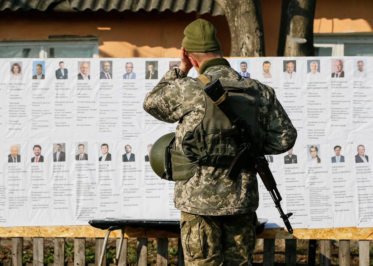 Украинский военнослужащий на избирательном участке в селе Зайцево, Украина