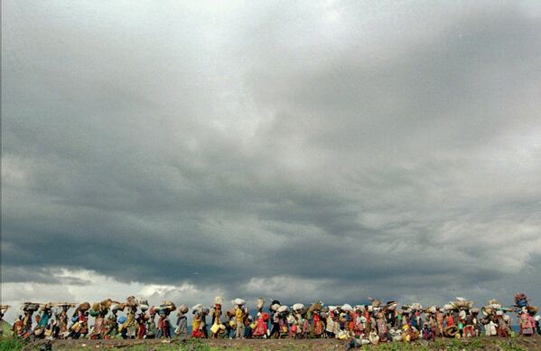Беженцы выходят из лагеря беженцев Мугунга