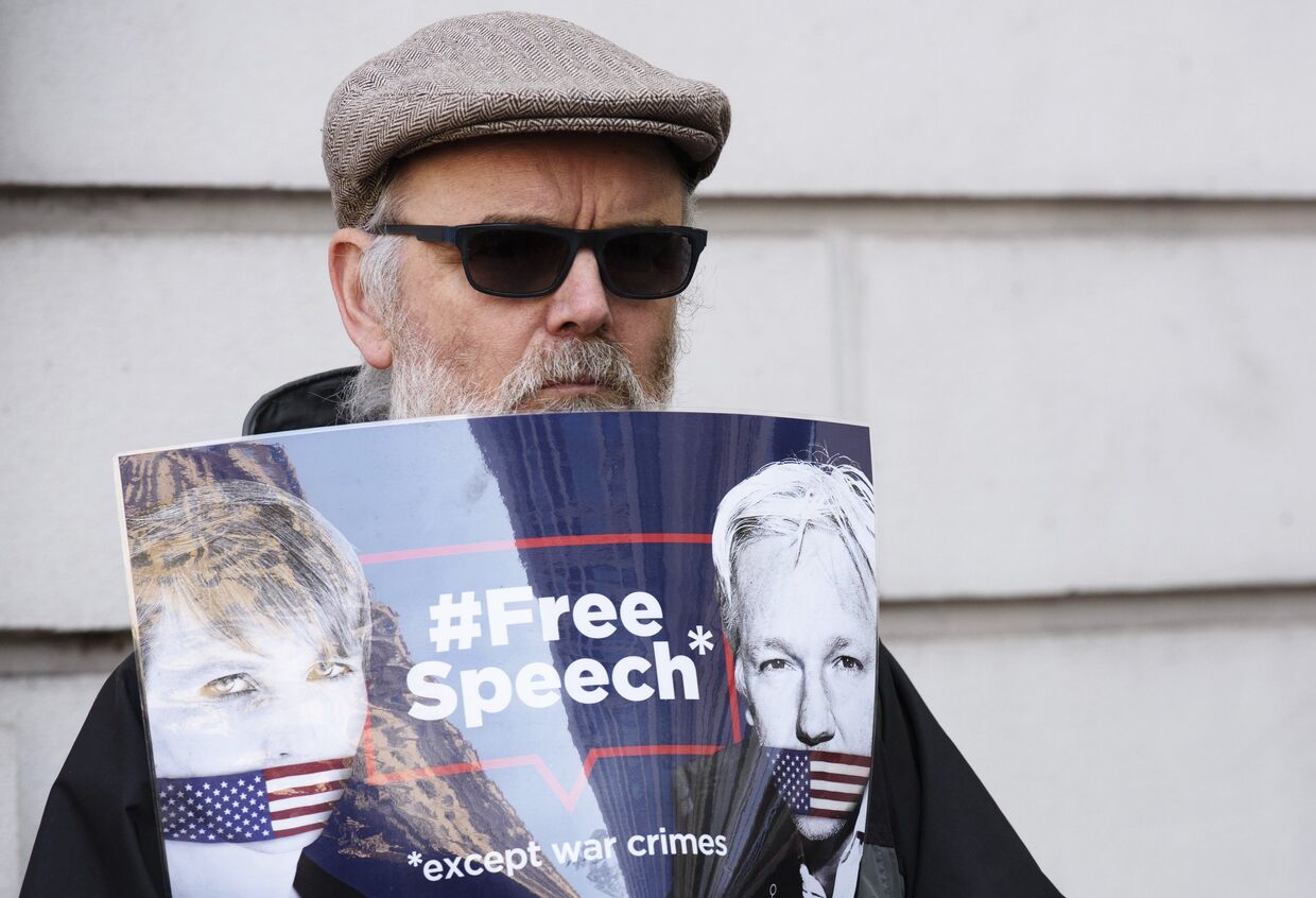 Мужчина стоит с плакатом в поддержку Джулиана Ассанжа в Лондоне